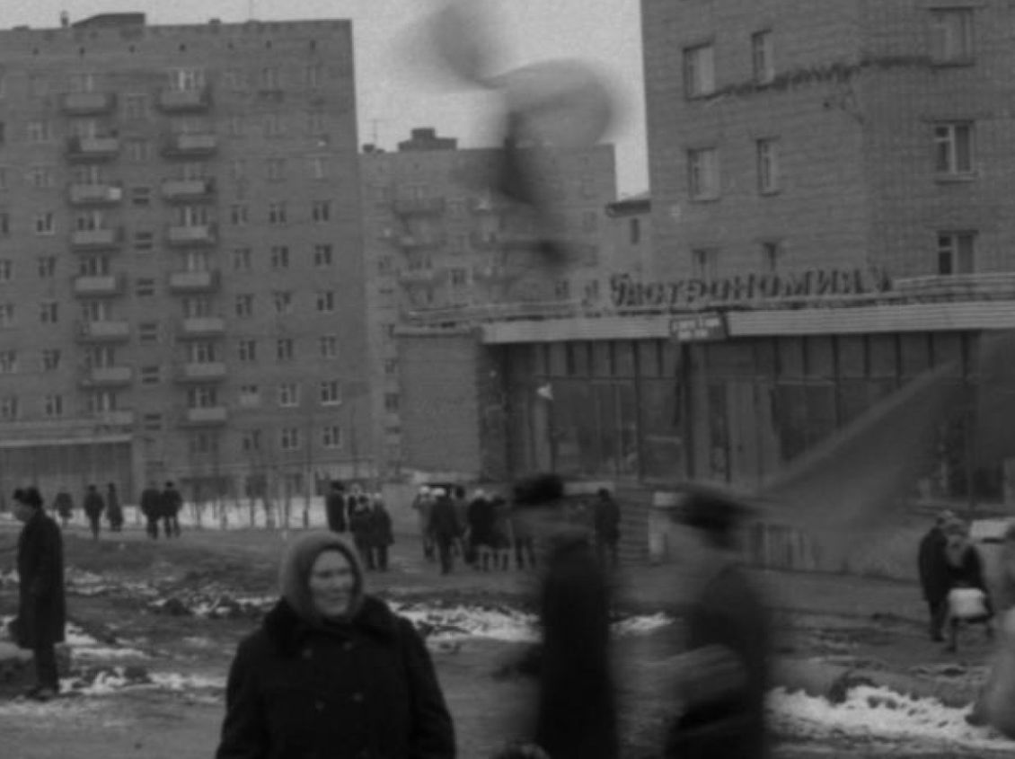Гастроном Кирова 9. В центре идущие мужчины с шариками и флагом. 1970-е годы. Ижевск.
